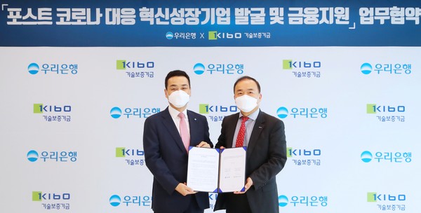 우리은행은 22일 서울 중구 우리은행 본점에서 기술보증기금과 ‘포스트 코로나 대응 혁신성장기업 발굴 및 금융지원’업무협약을 체결했다. 강신국(왼쪽) 우리은행 IB그룹장 겸 우리금융그룹 CIB총괄이 백경호 기술보증기금 상임이사와 기념촬영을 하고 있다/사진제공=우리은행