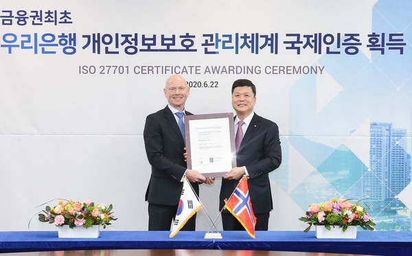 우리은행은 국제표준 개인정보보호 인증인 ‘ISO27701’ 를 금융권 최초로 획득했다. 권광석 우리은행장(오른쪽)이 프로데 술베르그 주한 노르웨이 대사와 지난 22일 우리은행 본점에서 열린 인증서 수여식에서 기념촬영을 하고 있다./사진제공=우리은행