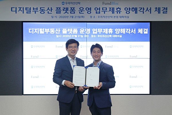 우리자산신탁은 지난 21일 서울 강남구 우리자산신탁 본사에서 펀드블록글로벌사와 디지털부동산 플랫폼 운영을 위한 업무협약을 체결했다. 이창재 우리자산신탁 대표이사(왼쪽)와 조찬식 펀드블록글로벌 대표이사가 기념촬영을 하고 있다./사진제공=우리은행