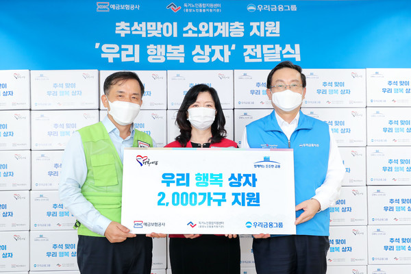 우리금융그룹과 예금보험공사는 추석을 맞아 홀로 계신 어르신들이 따뜻한 한가위를 보낼 수 있도록 우리 농산품으로 채워진 ‘우리행복상자’ 2000개를 15일 독거노인종합지원센터에 전달했다. 손태승 우리금융그룹 회장(오른쪽), 김현미 독거노인종합지원센터장(가운데), 위성백 예금보험공사 사장이 우리행복상자 전달식 기념촬영을 하고 있다./사진제공=우리금융